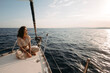 © Westend61 - Woman sitting on sailboat at sunset