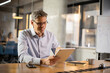 © JustLife - Portrait of businessman in office. Man using digital tablet. Businessman having video call