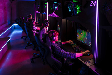 Wall Mural - Team of gamers playing online video game in cybersport club