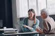 © gstockstudio - Financial advisor pointing laptop and smiling while discussing options with senior woman in office