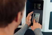Man Entering Pin In ATM Machine