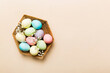 Happy Easter composition. Easter eggs in basket on colored table with gypsophila. Natural dyed colorful eggs background top view with copy space