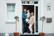 © Westend61 - Happy family standing at front door