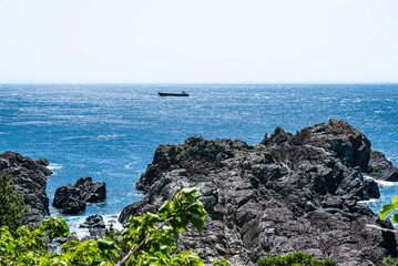 The sea and a tanker seen from the rocks