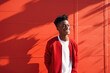 © Miquel - A happy african american teenager on a red wall. Generative AI