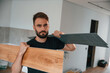 © standret - Holding the planks. Man is installing new laminated wooden floor