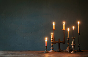 Wall Mural - burning candles in vintage candlesticks on dark background