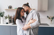 © BullRun - Happy couple hugging in kitchen