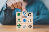 Fototapeta Mapy - Businessman assemble ESG wording on wooden cube block for sustainable organization development and corporation of Environment Social Governance concept.
