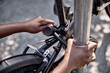 © kerkezz - Close-up of a woman's hands locking a bicycle to a lamp post.