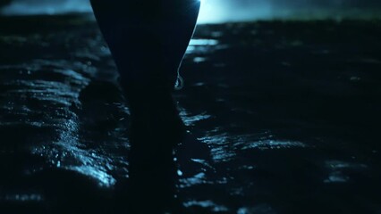 a man walking in the dark through the fog and darkness after the rain.