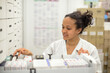© AUFORT Jérome - young woman pharmacist checking her stock