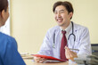 © SKW - Asian doctor talking to patient with smile to encourage patients at the hospital
