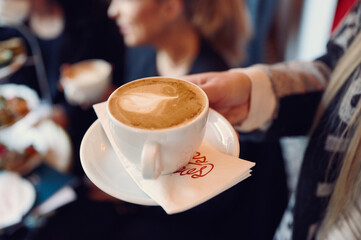 a close up of a person holding a cup of coffee