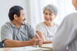 © SKW - Asian seniors who are healthy, in a good mood, smiling, talking with financial or life insurance staff to take care of life after retirement.