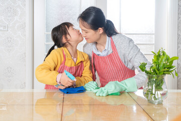 The little girl and her mother are cleaning at home together