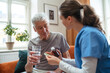 © Halfpoint - Nurse giving pills senior man in his home.