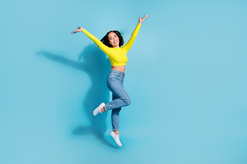 Poster - Full body portrait of overjoyed cheerful lady jumping raise arms empty space ad isolated on blue color background