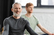 © LIGHTFIELD STUDIOS - Bearded middle aged man smiling at camera in yoga studio.