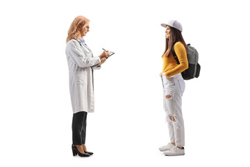 Sticker - Full length profile shot of a female student standing and talking to a female doctor writing a document