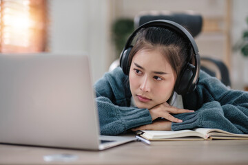 Bored young asian girl student studying, looking upset at laptop screen, attend boring online classes or lecture. Tired bored lazy