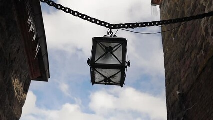 Poster - ancient lantern on a chain in the walls of the castle