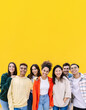 © Xavier Lorenzo - Happy young group of teenage people smiling at camera standing over yellow background. Diverse student friends showing unity and community embracing each other. Copy space for text