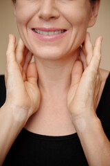 Wall Mural - Cropped image of smiling mature woman massaging her neck to reduce swelling