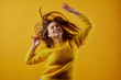 © st.kolesnikov - girl in a yellow sweater dancing on a yellow background