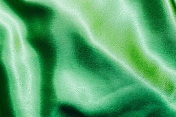 Wall Mural - Green shiny texture of silk satin satin with folds.