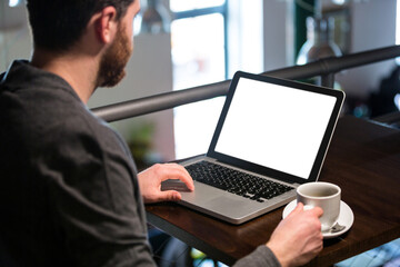 Poster - Man holding coffee cup and using laptop