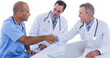 Male doctor and surgeon shaking hands at table