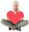 Upset man sitting holding heart shape