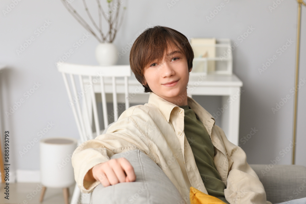 Teenage boy sitting on sofa at home