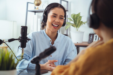 Young Asian woman use microphones wear headphones with laptop record podcast interview for radio. Content creator concept.