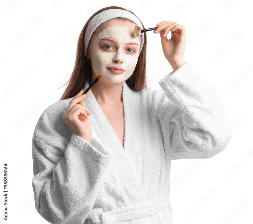 Young woman with applied turmeric mask and brushes on white background