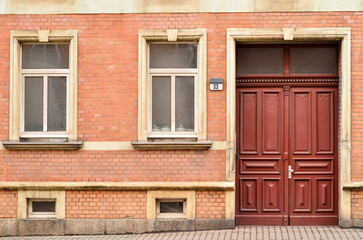 Wall Mural - View of brick building with wooden door and windows
