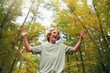 Happy Teen Boy Smiling as He Hikes in the Autumn Woods