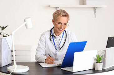 Canvas Print - Mature female doctor video chatting with patient. Concept of telemedicine