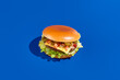 Health-conscious alternative meat burger with jalapeno & fresh greens on blue. Modern minimalist food photography, horizontal composition. eco-friendly, protein-packed, delicious veggie burger