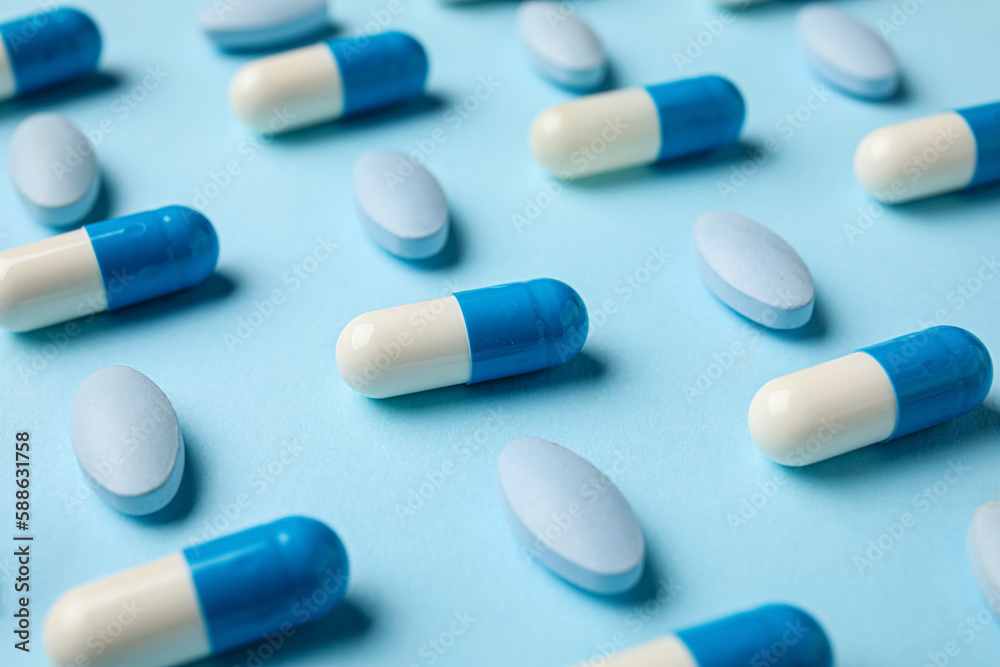 Different pills on blue background, closeup