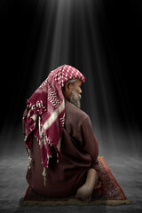 Poster - Muslim man with a beard wearing keffiyeh with agal in praying position (salat) on the prayer rug