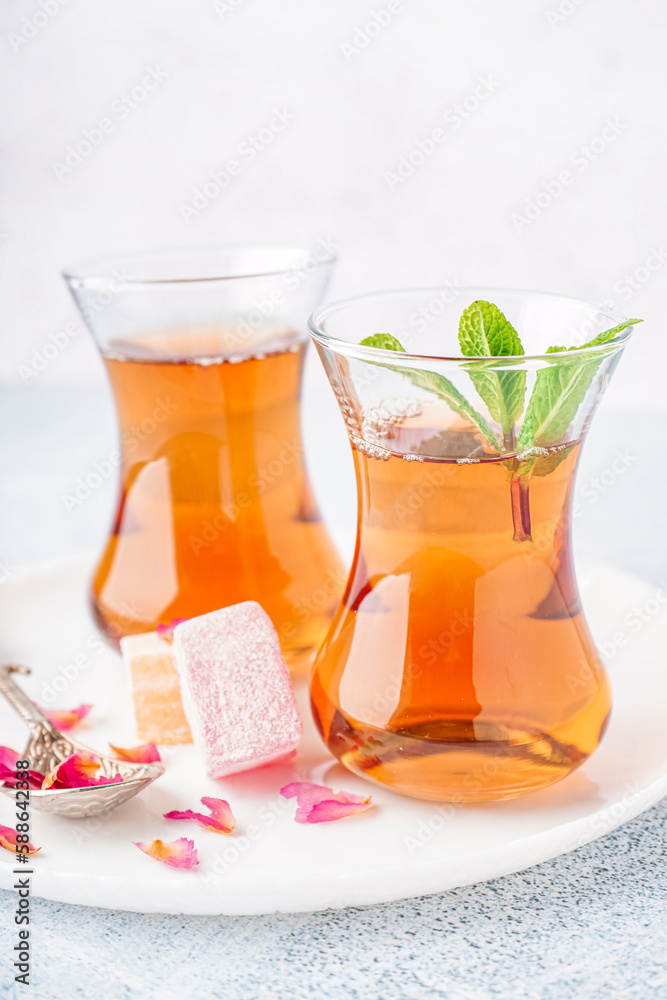 Glasses of tea and Turkish delight on light background