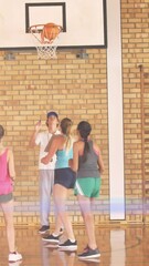 Wall Mural - Animation of light spots over diverse schoolchildren playing basketball at gym