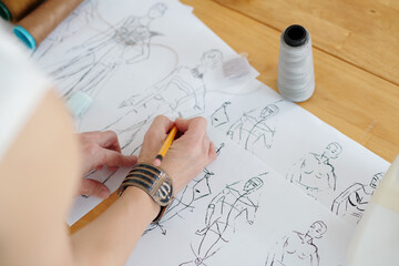 Wall Mural - Hands of fashion designer drawing sketches for fashion collection