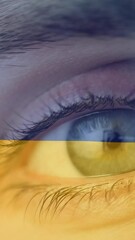 Poster - Animation of flag of ukraine waving over open eye of caucasisan woman