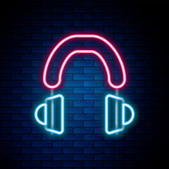 Sticker - Glowing neon line Headphones icon isolated on brick wall background. Earphones. Concept for listening to music, service, communication and operator. Colorful outline concept. Vector