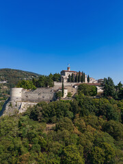 Wall Mural - Vertical panoramic view from a drone of a hill (colle Cidneo) with park and historical castle in the Brescia town. Lombardy, Italy