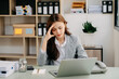 © Nuttapong punna - Woman who is tired and overthinking from working with tablet and laptop at modern office.