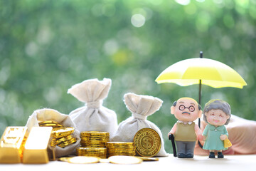 Wall Mural - Mutual fund,Love couple senior and hand holding the umbrella with gold coin money in the bag on natural green background, Save money for prepare in future and pension retirement concept